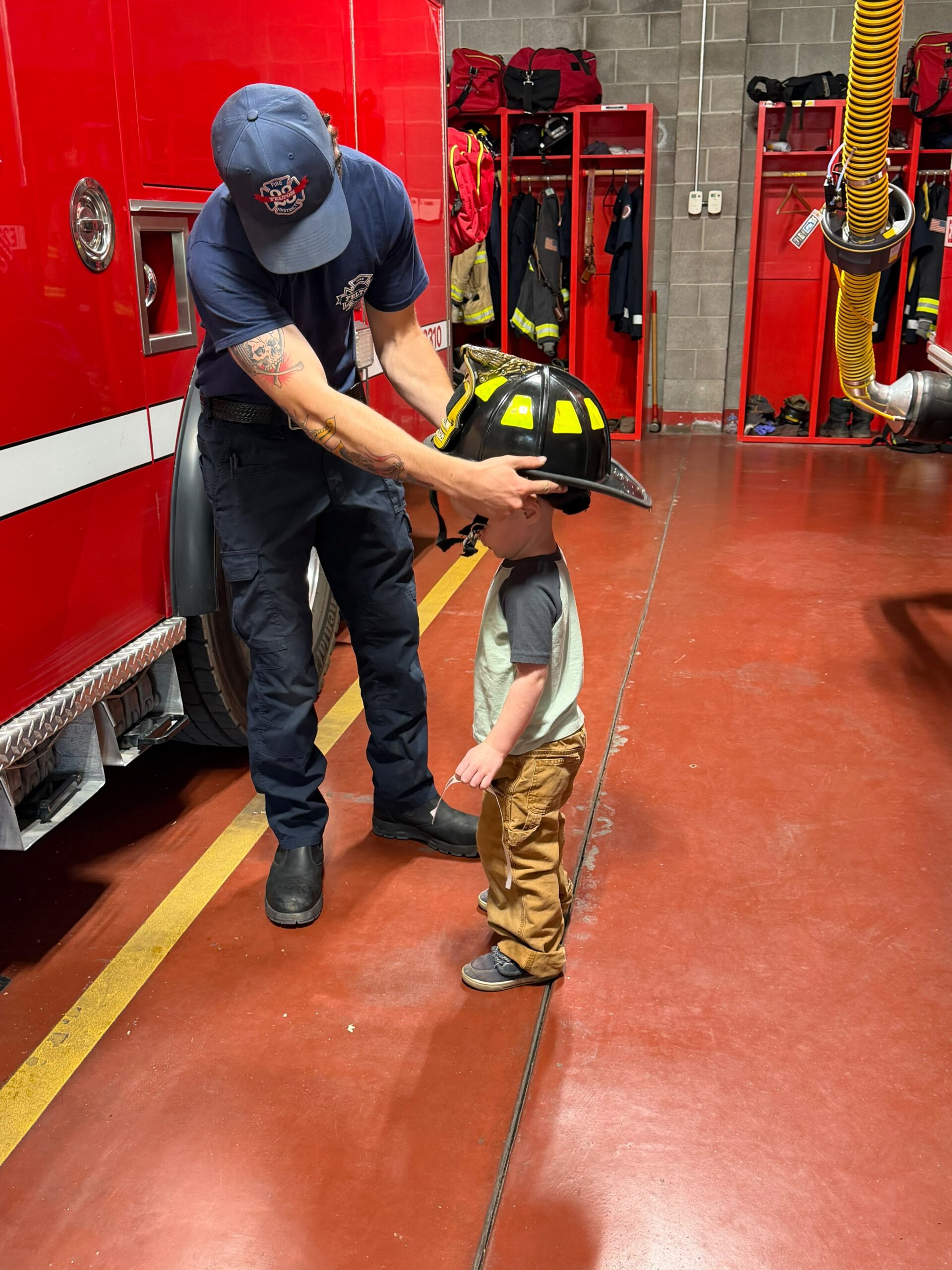 Young child trying on firefighter helmet at FFPD