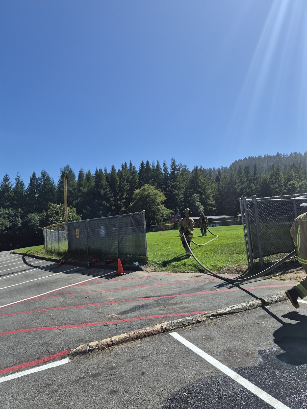 Firefighters advancing hose across the field